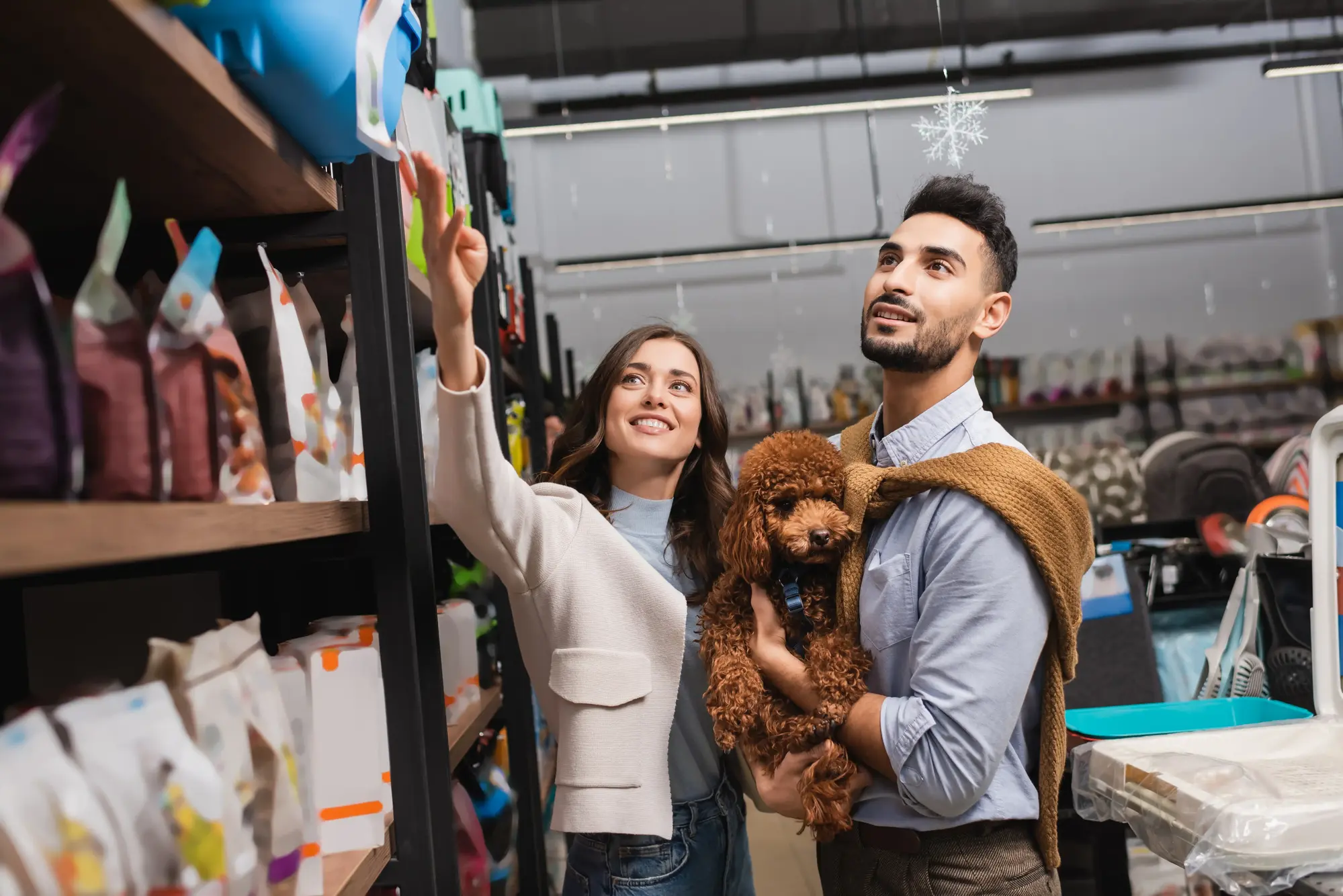 Retail pet store employee helping customer and dog