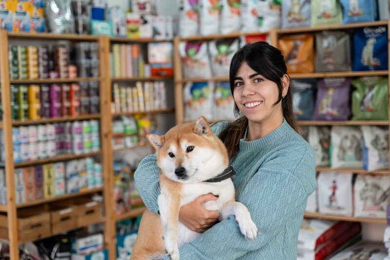 Woman holding dog at pet store