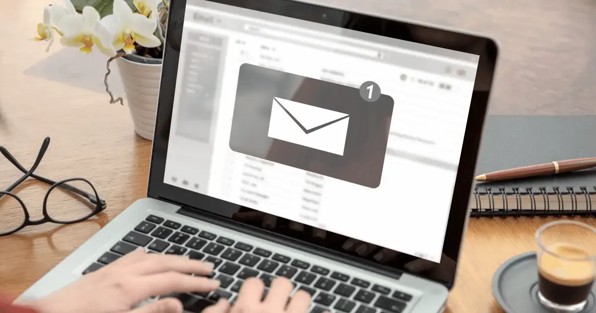 a person typing out an email on a laptop